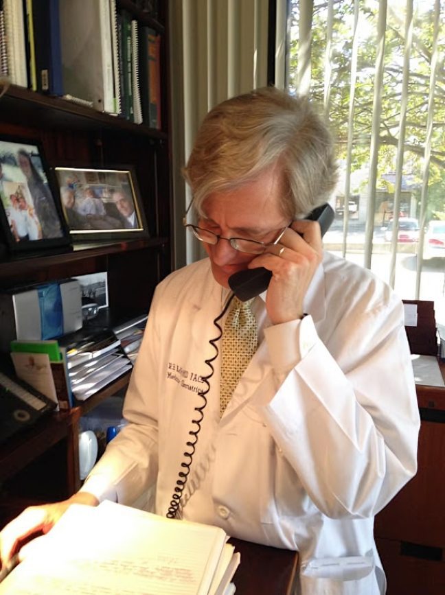 Physician reading documents at desk