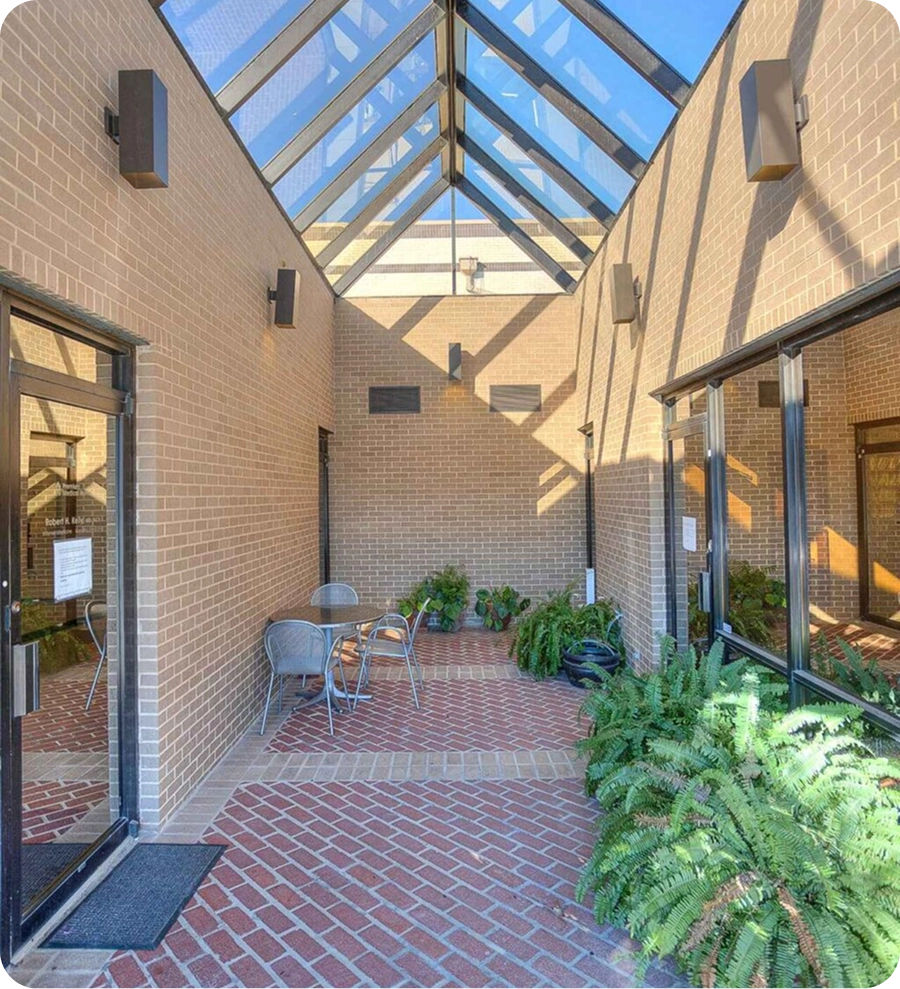 Sunlit courtyard with metal chairs.
