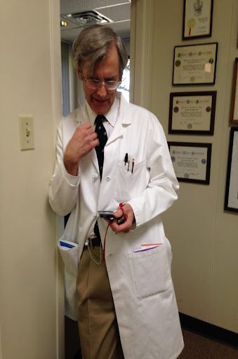 Doctor in white coat holding a device