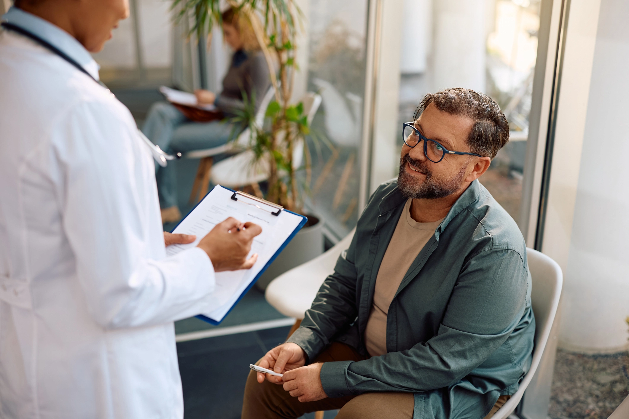 Medical professional consults smiling male patient
